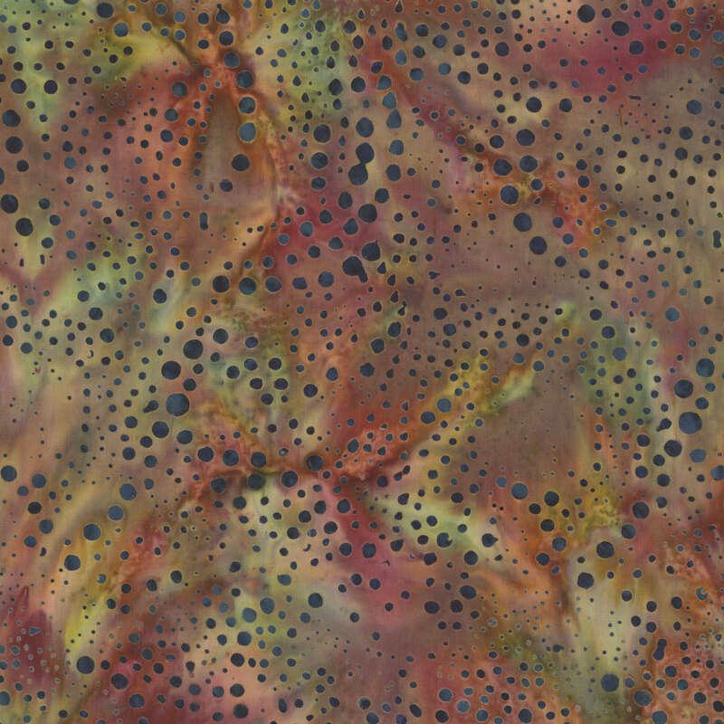 earthy batik fabric featuring scattered dots in varying sizes and deep blue-gray tones against a softly mottled background of green, rust, muted burgundy, and warm brown.