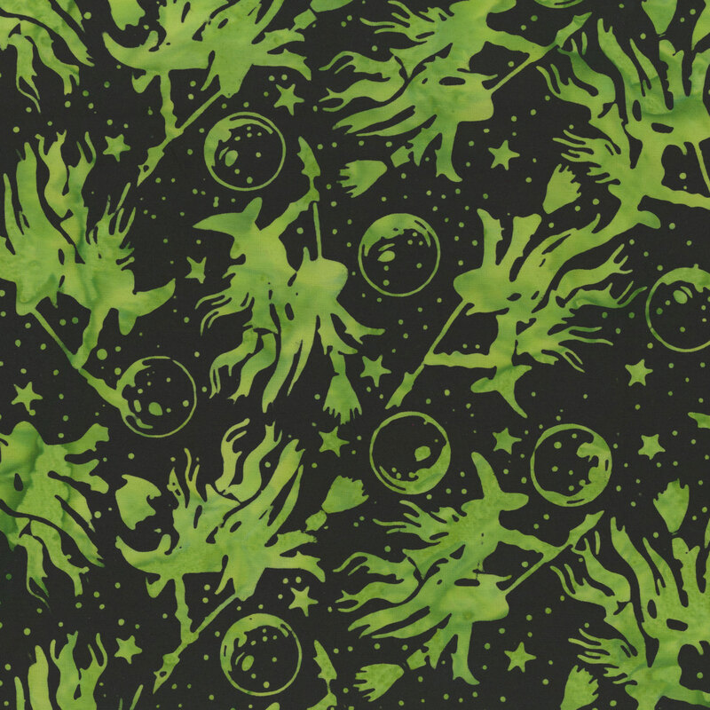 mottled lime green witches on brooms scattered across a black night sky accented with stars and moons.