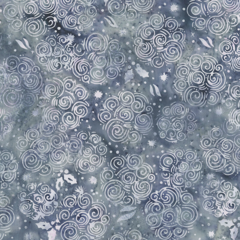 batik fabric featuring soft lavender and icy blue clusters of swirls, dots, snowflakes, holly leaves on a mottled slate background.