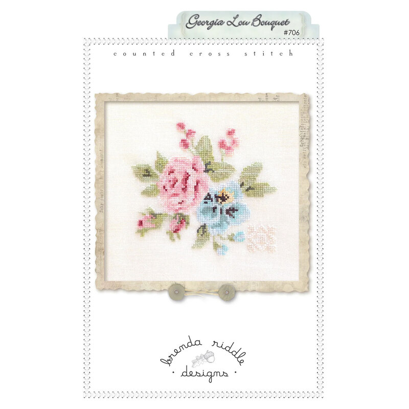 Front of Georgia Lou Bouquet cross stitch pattern featuring the finished pink and blue floral project framed.