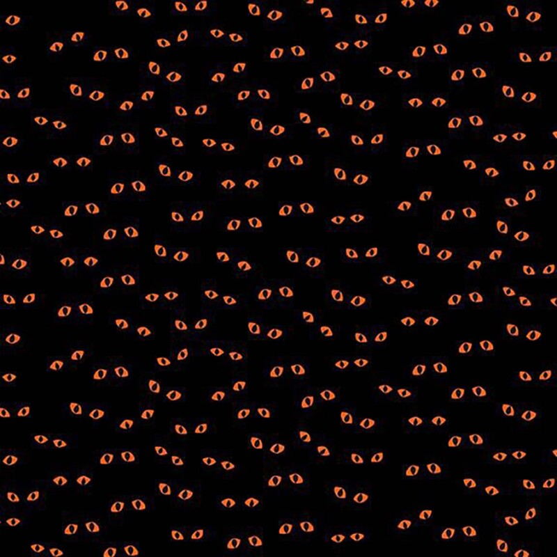 Spooky black fabric with a tossed pattern of orange eyes.