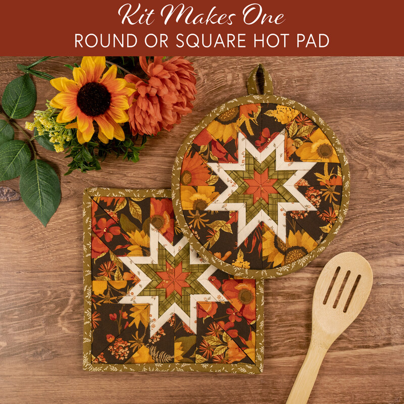 The completed Folded Hot Star Pads colored in autumn fabrics from the Bountiful collection by Riley Blake Designs, staged on a wooden table with coordinating décor.