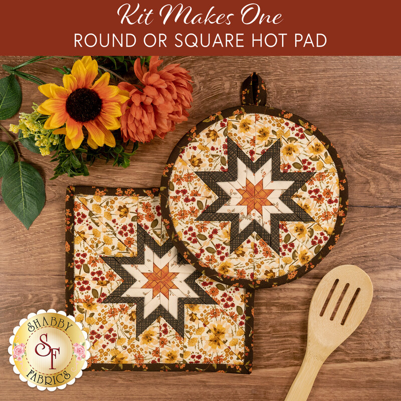 The completed Folded Hot Star Pads colored in autumn fabrics from the Bountiful collection by Riley Blake Designs, staged on a wooden table with coordinating décor.