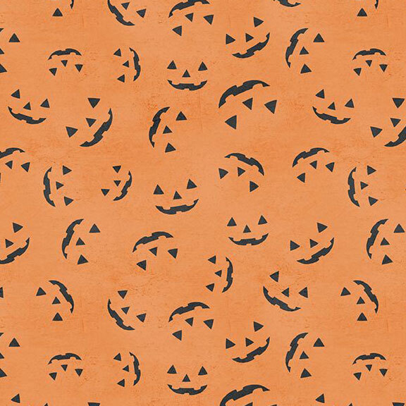Textured pumpkin orange fabric with a tossed design of grinning jack-o'-lantern faces.