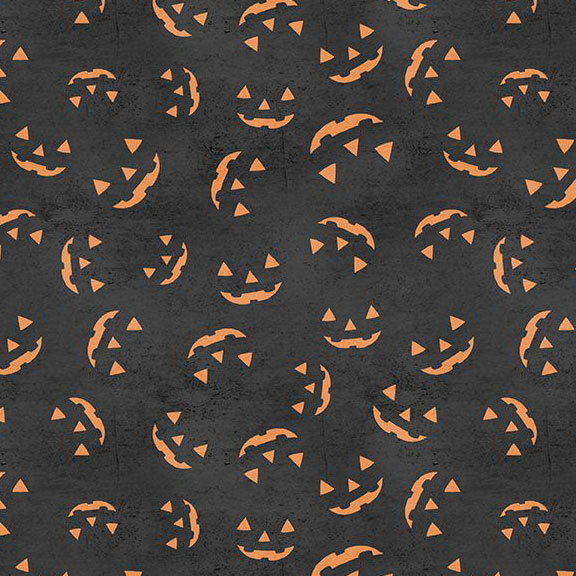 Textured, soft black fabric with a tossed design of grinning, orange jack-o'-lantern faces.