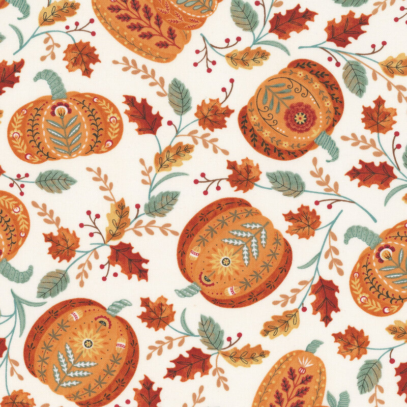 A white fabric with folk-art pumpkins among scattered leaves.