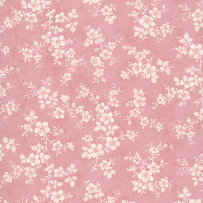 Pink fabric with a pattern of florals entwined with leafy vines.