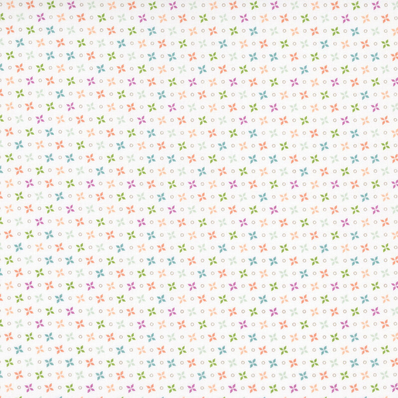 A white fabric with multicolored four-petal flower motifs and circles in rows.