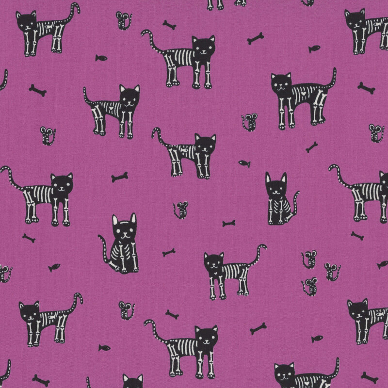 A magenta fabric with scattered skeleton cats, mice, and fish.