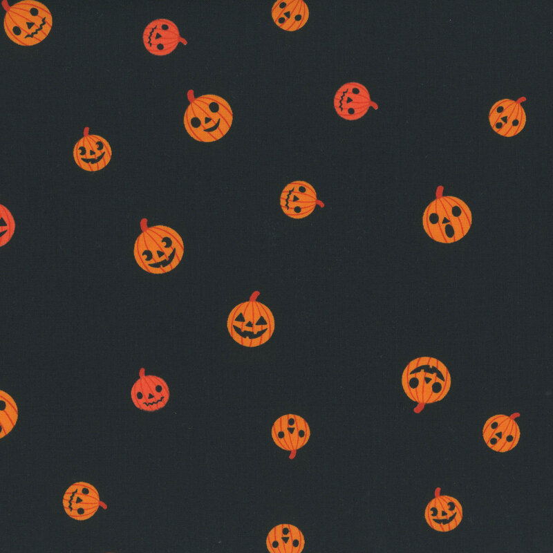A black fabric with tossed jack-o'-lanterns.