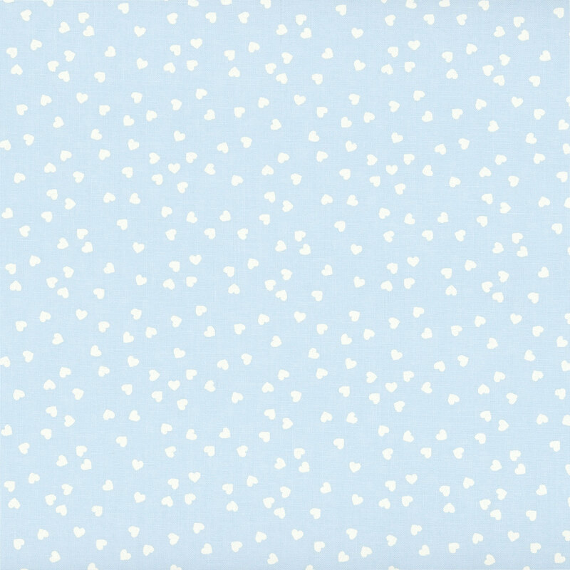 Baby blue fabric with a playful tossed pattern of small cream hearts.
