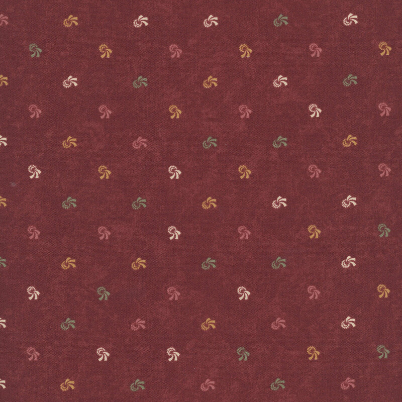 Mottled burgundy fabric with red, green, ocher, and white swirling motifs.