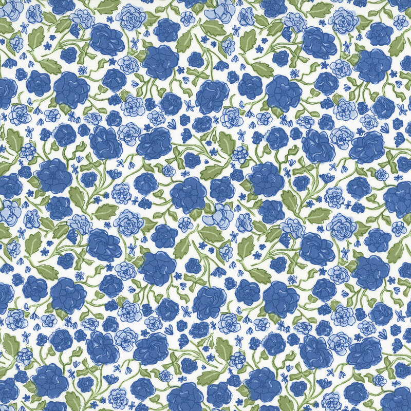 A white fabric with blue florals and green leafy stems.