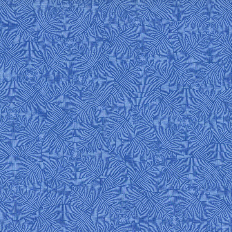 A blue fabric with overlapping blue concentric circles made of fine radiating lines.