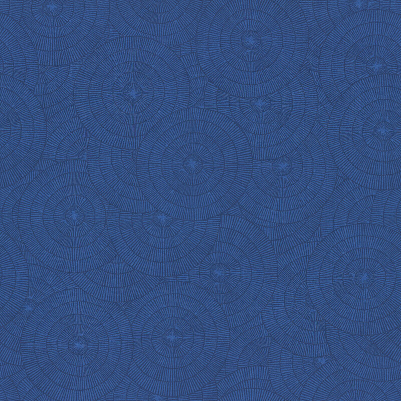 A deep blue fabric with overlapping blue concentric circles made of fine radiating lines.