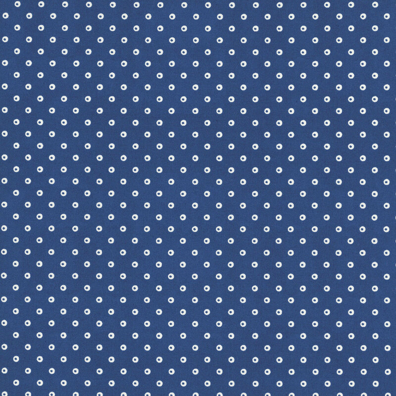 An indigo fabric with hollow white polka dots.