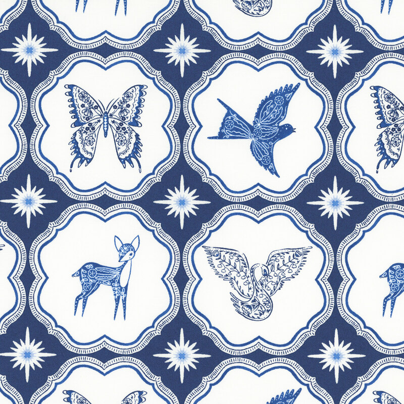 A dark blue fabric with blue butterflies, birds, and deer inside scalloped ornamental frames separated by blue and white starbursts.