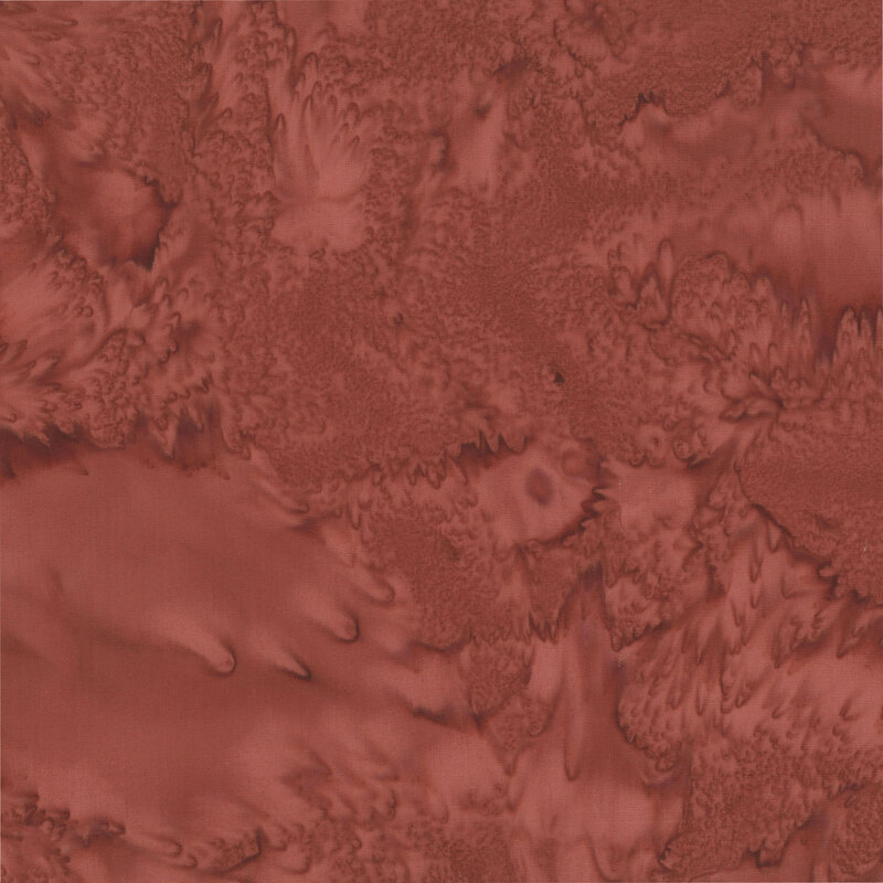 Marbled and mottled rusty red batik fabric.