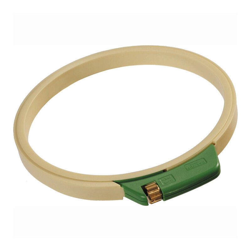 Round cream plastic embroidery hoop with a green covered tightening mechanism and brass adjustment screw.