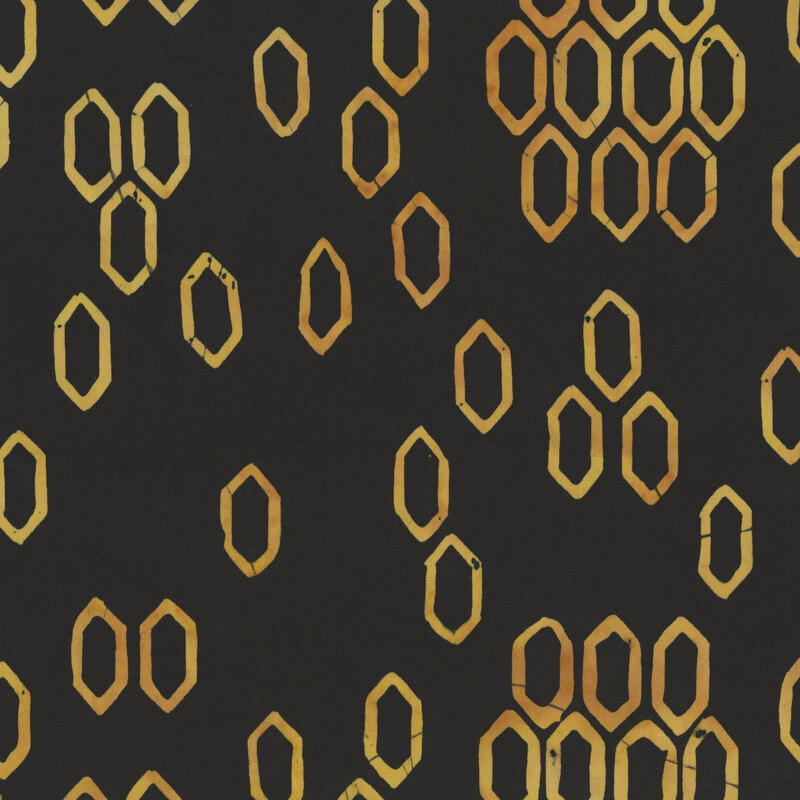 This mottled black batik fabric features yellow hexagonal shapes reminiscent of a bee hive. 
