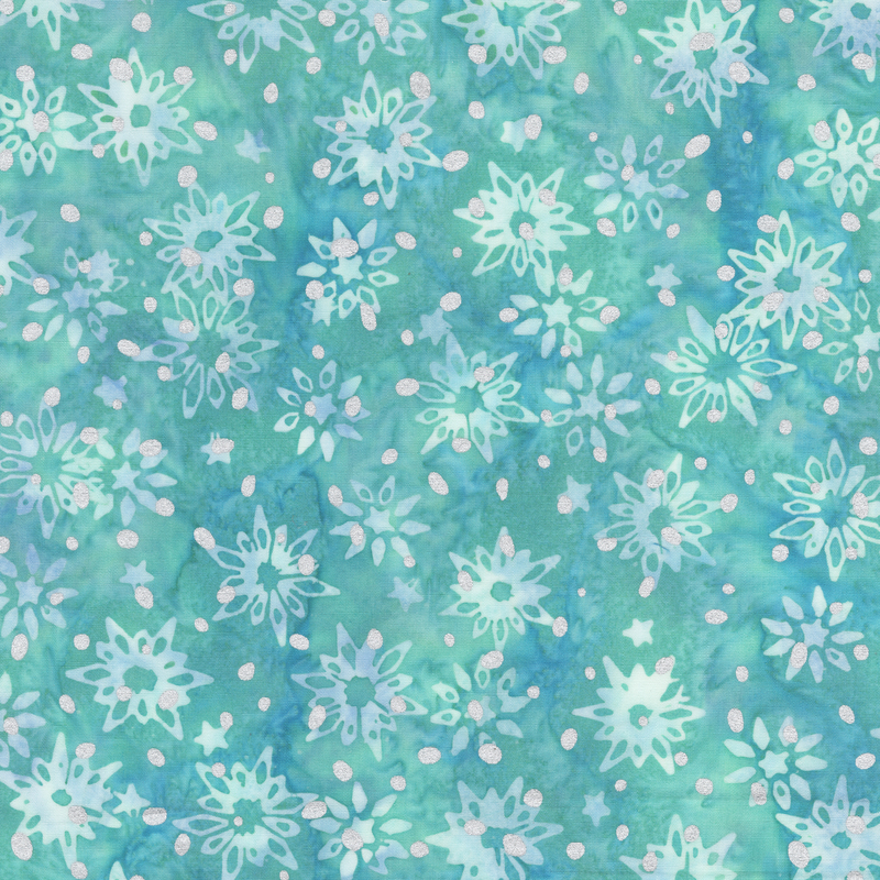 A teal batik fabric with assorted aqua and light blue snowflakes and scattered metallic silver dots.