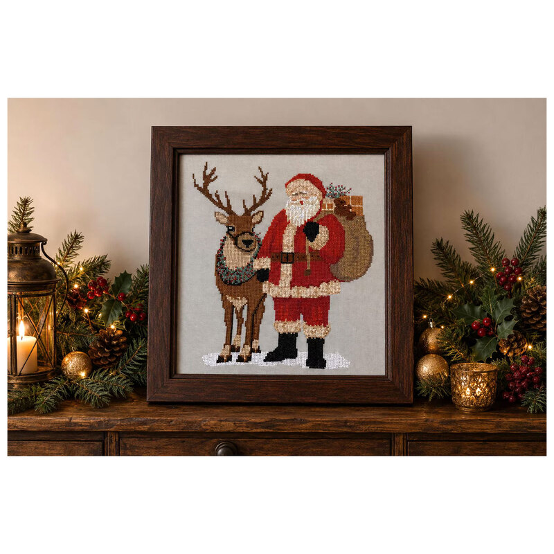 A Christmas cross stitch design with Santa standing beside a reindeer adorned with festive greenery and carrying a sack filled with gifts.