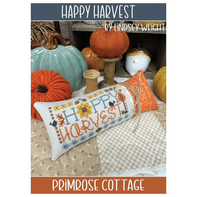 Front cover of the pattern showing the completed project as a pillow, staged with pumpkins and autumn-themed decor.