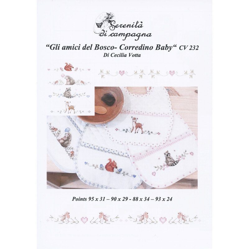 Front cover of the cross stitch pattern with the finished designs scattered across a wood table next to a wood bowl.