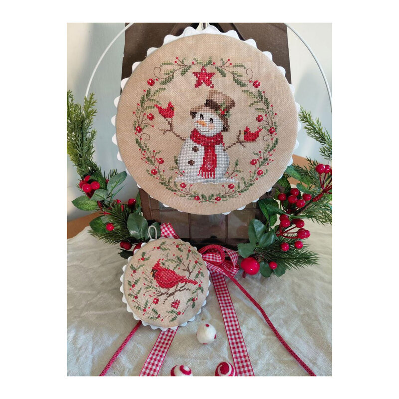 Photo of the finished pattern stitched onto a neutral finishing board in a wintry scene. 