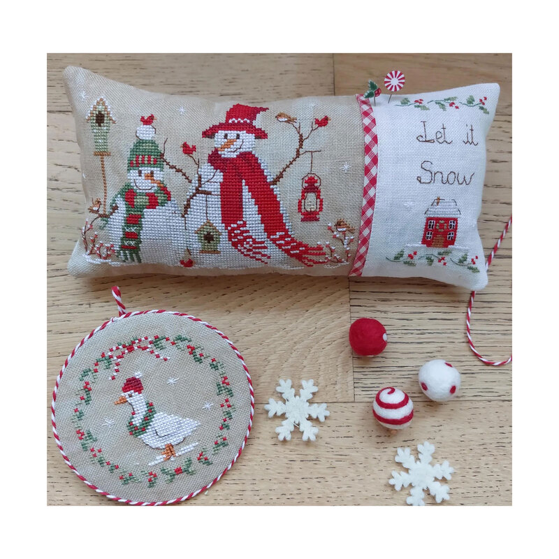Photo with the finished patterns stitched onto a pillow on top of a wooden table.