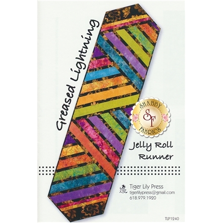 Image of a sewing pattern cover titled Greased Lightning Jelly Roll Runner by Tiger Lily Press. The design features a hexagon-shaped table runner with an arrangement of colorful diagonal stripes in vibrant colors like purple, orange, green, and blue, set against a patterned background. The top corner includes the title and the logo of Shabby Fabrics.