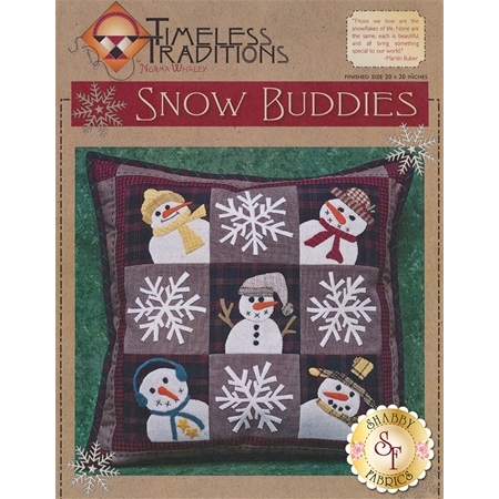 A decorative pillow cover titled Snow Buddies featuring a quilted design with nine patches, each containing snowmen and snowflakes in various colors. The background is dark plaid, and the design includes playful elements like hats and scarves on the snowmen. The top of the image has the Timeless Traditions logo and product title.