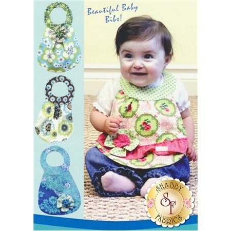 A baby girl wearing a colorful bib smiles at the camera. Three designs of baby bibs are displayed on the left side, featuring floral patterns. The text at the top reads Beautiful Baby Bibs! with a logo for Shabby Fabrics at the bottom.