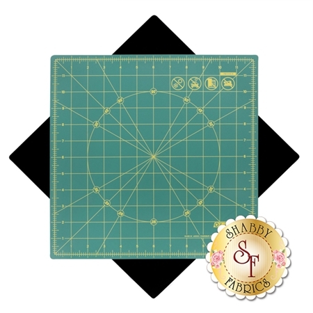 Green cutting mat with grid lines and measurements, centered on a black diamond background, featuring a Shabby Fabrics logo.