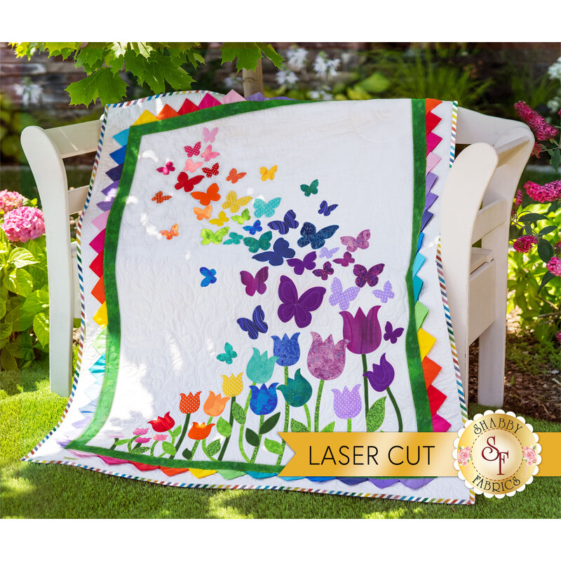 The beautiful Blooming Butterflies quilt draped over a chair outside | Shabby Fabrics