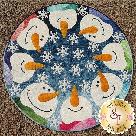 A circular design featuring eight smiling snowmen with orange carrot noses, surrounded by snowflakes on a blue background. Each snowman wears a different colored scarf, and they are arranged in a circle.