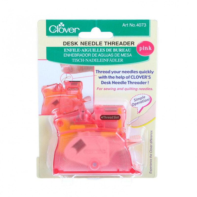 A pink Clover Desk Needle Threader displayed on its packaging, which includes text instructions for threading needles quickly.