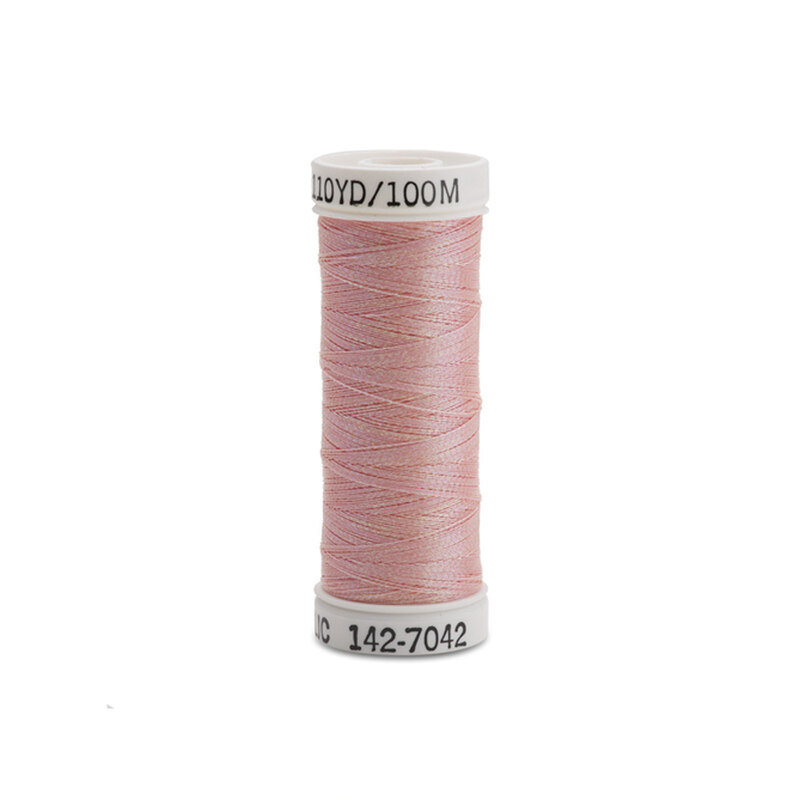 A spool of pink thread with a white label.