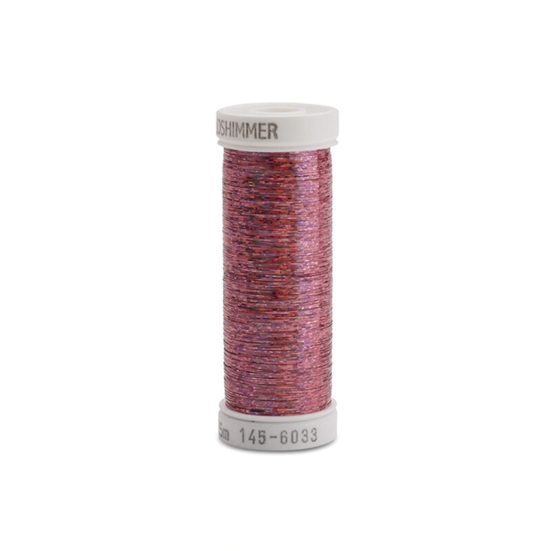 A spool of pink metallic sewing thread with a white label.