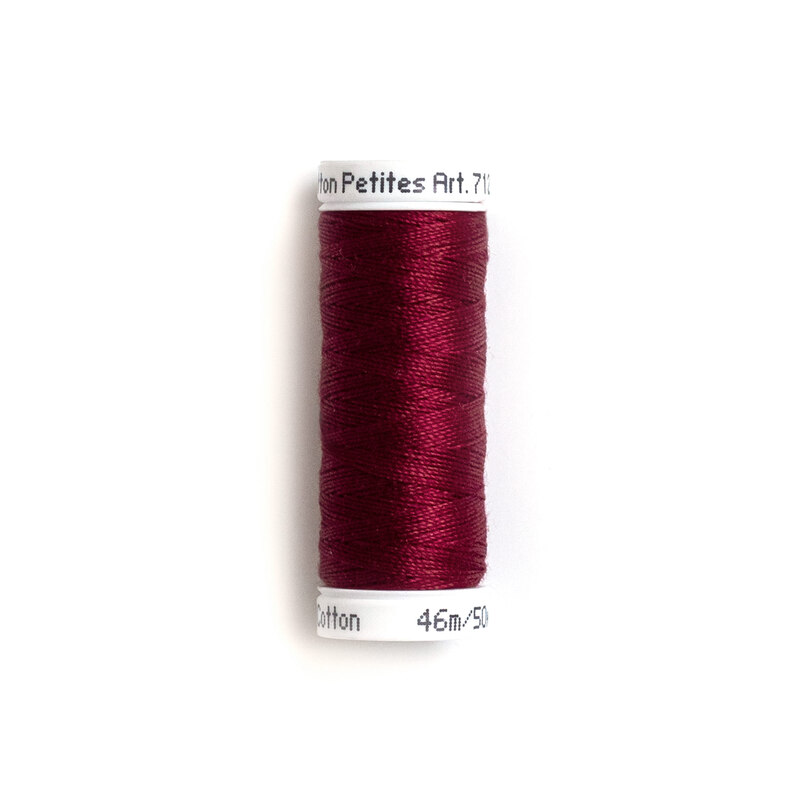 Spool of deep burgundy sewing thread.