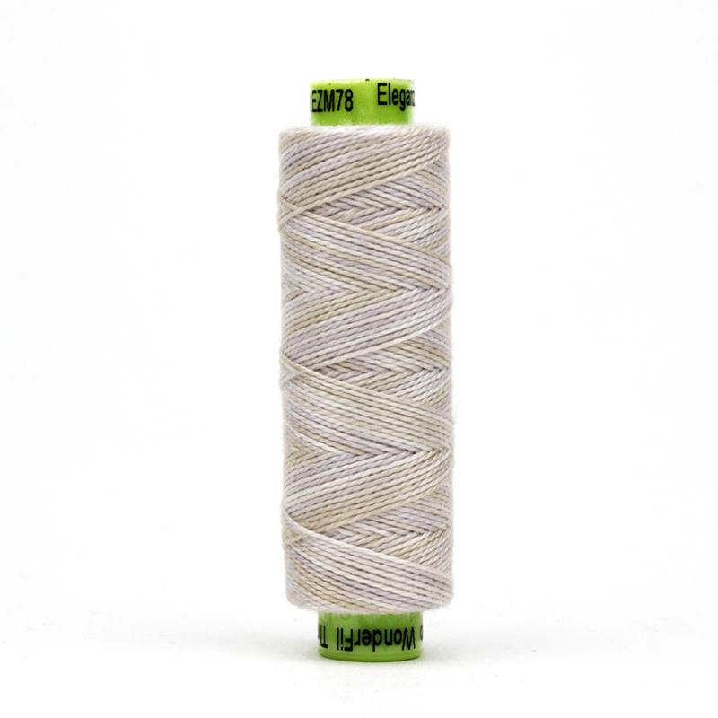 A spool of WonderFil Eleganza EZM78 Ginned Cotton thread on a white background