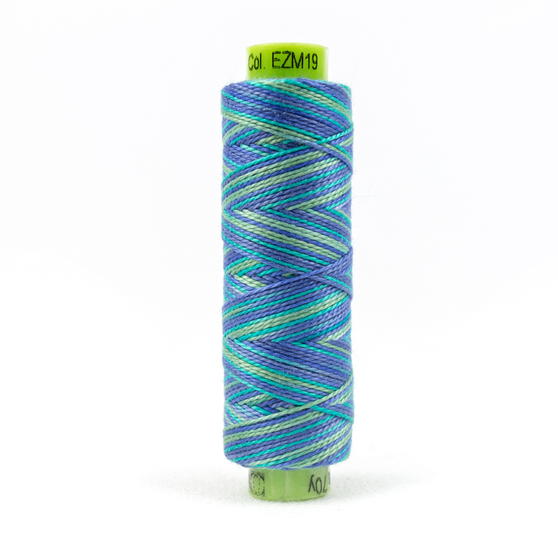 A spool of WonderFil Eleganza EZM19 Island Oasis thread on a white background