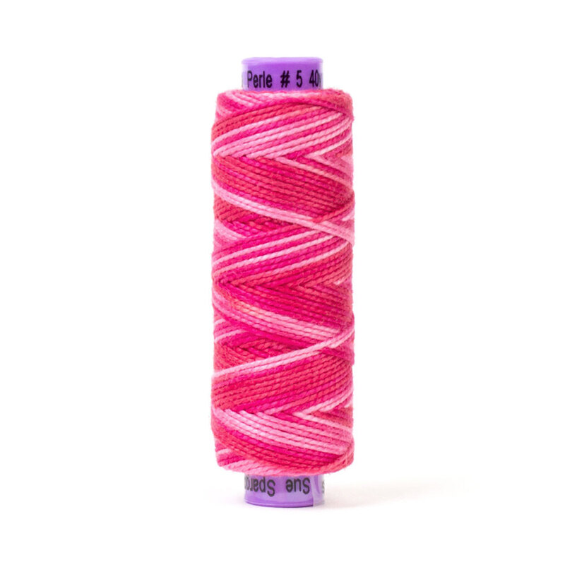 A spool of threaded yarn featuring a gradient of pink shades in a zigzag pattern. The top of the spool is labeled Perle #5 and the brand name is visible at the bottom.