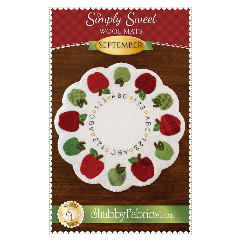 A Shabby Fabrics pattern featuring a white circular mat with scallops and red and green apples along the edges