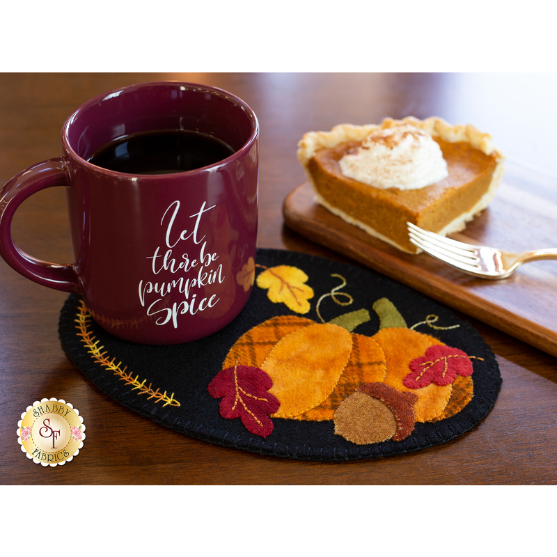 The November Wooly Mug Mat displayed with a cup of cocoa and slice of pie!