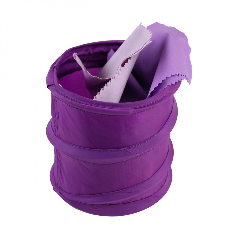 An expanded purple collapsible tote bucket with scraps of purple fabric in it