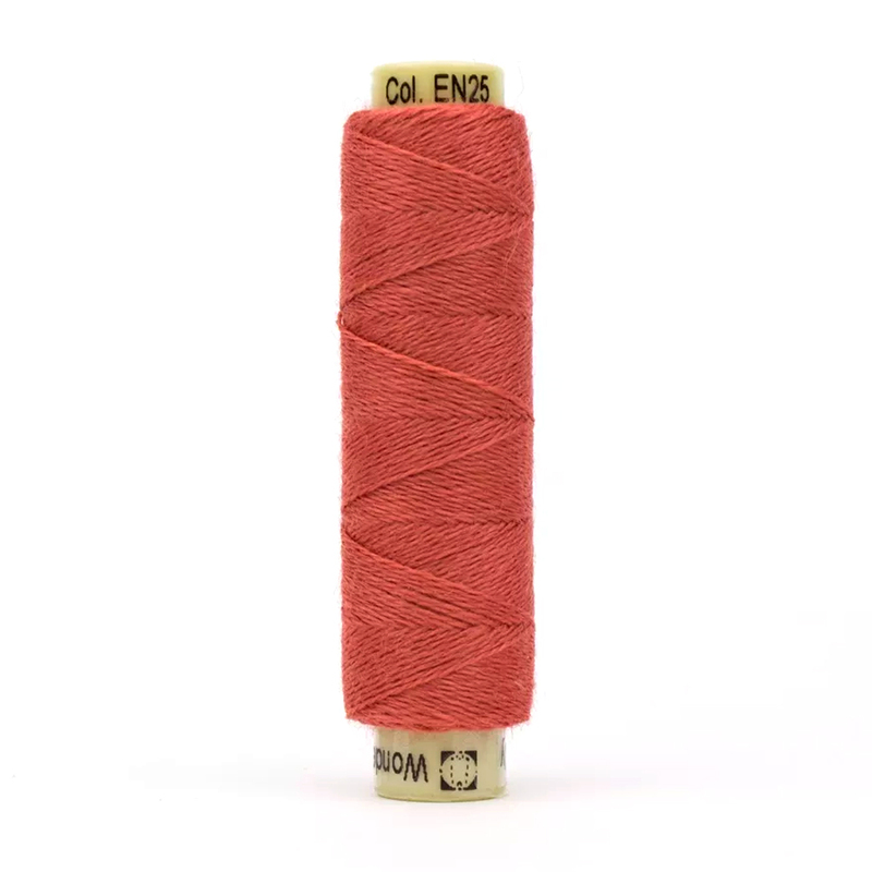 A spool of the salmon colored Ellana EN-25 Salmon thread on a white background