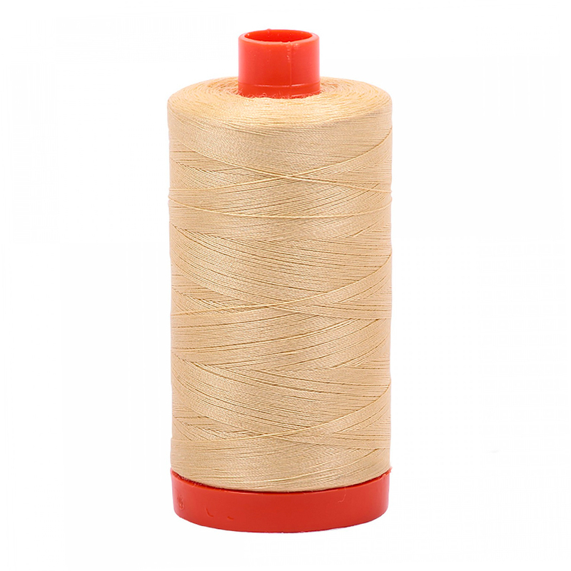 A spool of Aurifil 2125 - Wheat thread on a white background