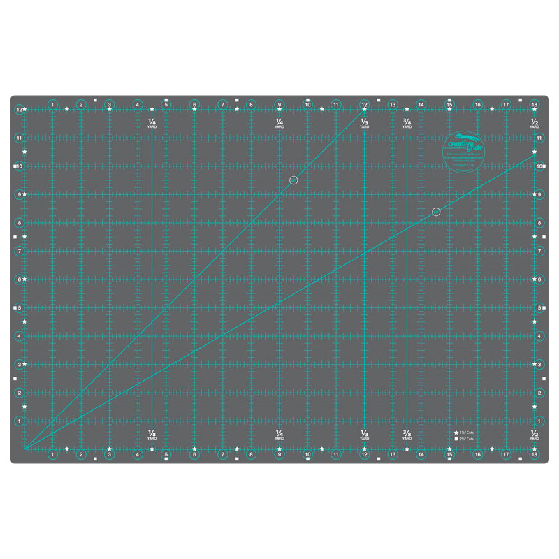 Cutting mat with grid lines in teal on a gray background, featuring measurement markings and angles.