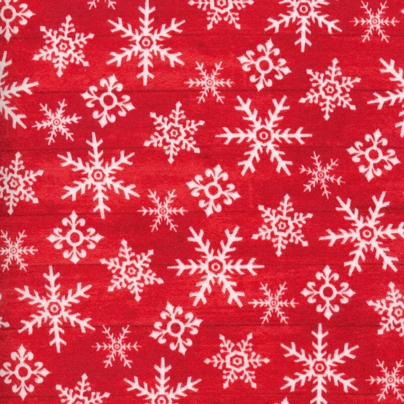 White tossed snowflakes on a red wood texture background